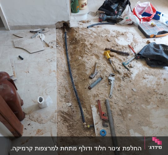 כלי עבודה וצינור חשוף בתהליך תיקון רצפה